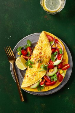 Domatesli omlet, avokado soğanlı biber ve tatlı mısır. Sağlıklı keto diyeti düşük karbonhidratlı kahvaltı