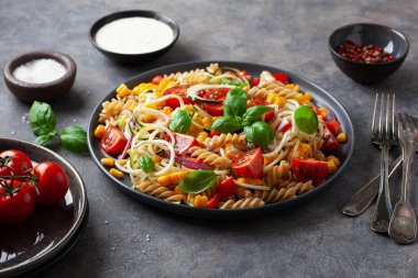 Sağlıklı makarna salatası, kabaklı mısır, domates ve fesleğen, vejetaryen öğle yemeği.