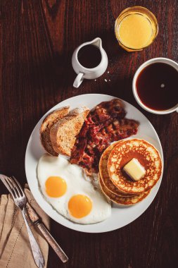 Geleneksel Amerikan kahvaltı yumurtaları pastırmalı krep ve tost.