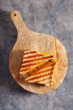 Gri beton arka planda ızgara peynirli sandviç.