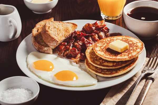 传统的全美式早餐鸡蛋煎饼加培根和吐司 — 图库照片