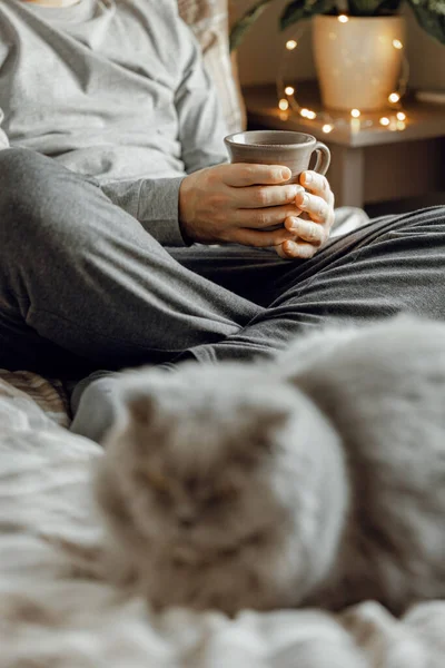 Kaukaski Mężczyzna Relaksujący Się Domu Pijący Kawę Korzystający Smartfona Łóżku — Zdjęcie stockowe