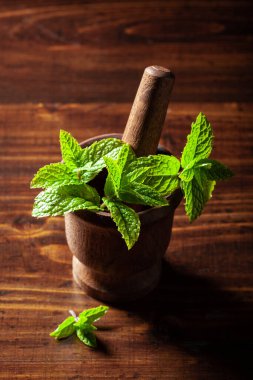 Taze nane yaprakları ahşap masa üzerinde antika havan topları.