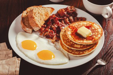 Geleneksel Amerikan kahvaltı yumurtaları pastırmalı krep ve tost.