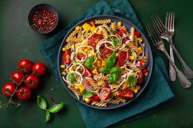 Sağlıklı makarna salatası, kabaklı mısır, domates ve fesleğen, vejetaryen öğle yemeği.