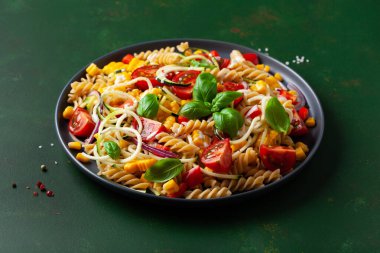 Sağlıklı makarna salatası, kabaklı mısır, domates ve fesleğen, vejetaryen öğle yemeği.