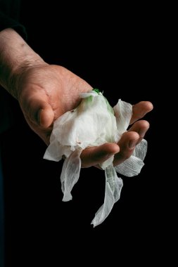 man's hand holding wilted flower, concept of melancholy sadness fatigue despair or depression