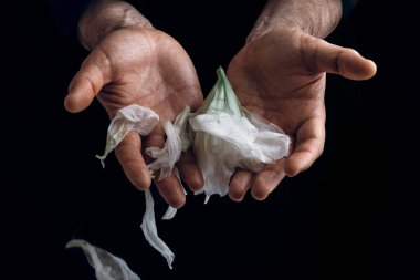 man's hand holding wilted flower, concept of melancholy sadness fatigue despair or depression