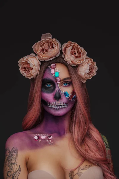 女性の美しさのショットで入れ墨と暗い背景にバラの花輪 — ストック写真