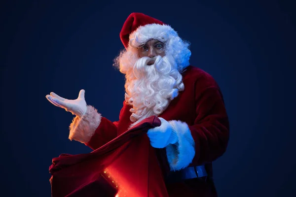 Studioaufnahme Eines Überraschten Weihnachtsmannes Mit Tasche Und Langem Bart Der — Stockfoto
