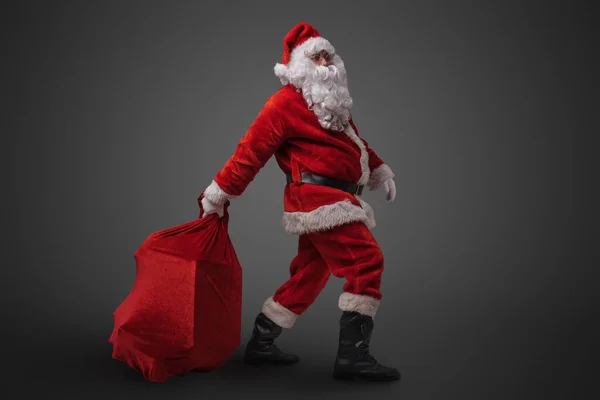Studioaufnahme Von Lustigen Weihnachtsmännern Die Große Tüte Mit Geschenken Vor — Stockfoto