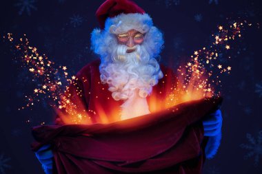 Sakallı Noel Baba 'nın portresi sihirli hediyelerle dolu çantaya bakıyor..