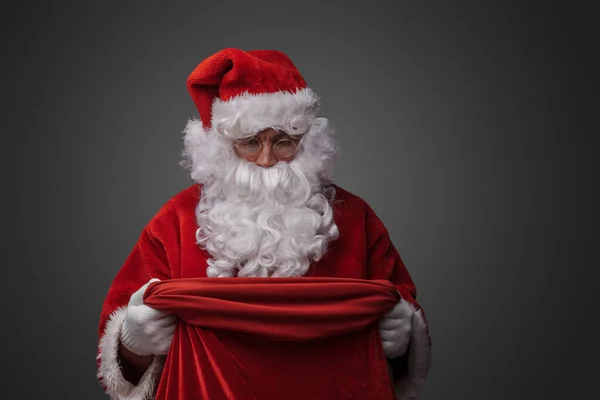 Ritratto Isolato Sfondo Grigio Santa Guardando Borsa Con Regali Natale — Foto Stock