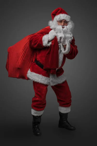 Zdjęcie Świętego Mikołaja Torbą Palcem Ustach Szarym Tle — Zdjęcie stockowe