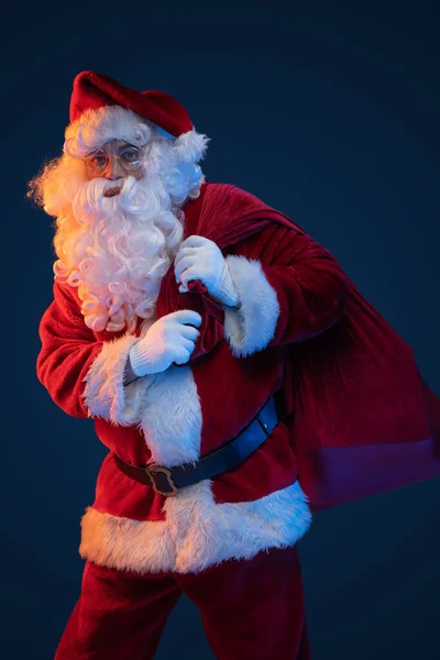 스튜디오는 어두운 배경에 가방을 다니는 산타의 사진을 찍었다 — 스톡 사진