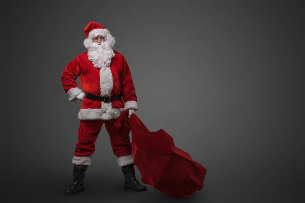 古典的な赤の衣装と眼鏡を保持バッグを身に着けているクリスマスサンタのショット — ストック写真