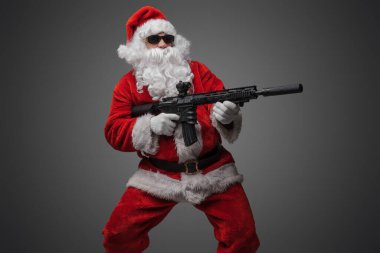 Uzun sakallı, tüfekli Noel Baba nişancısının stüdyo fotoğrafı..