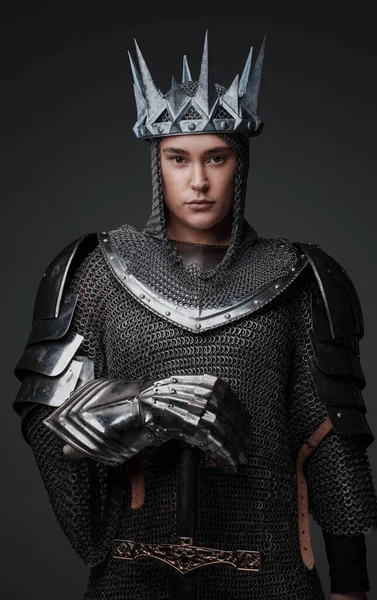 Studio shot of medieval female knight with crown and chainmail.