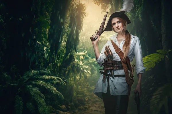 Portrait of buccaneer woman with pistols and hat in jungle of tropical island.