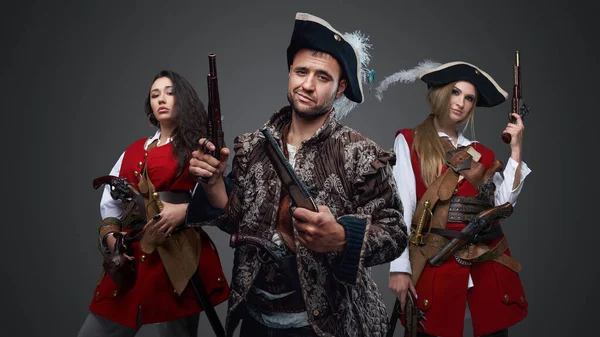 海賊男のショットと2人の女性とともにフリントロック銃グレーの背景 — ストック写真
