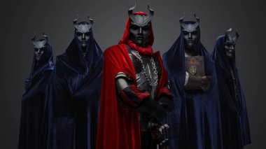 Portrait of four followers and their leader of dark cult dressed in dark robes.