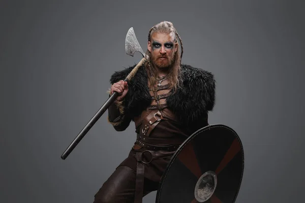 スタジオショットの恐ろしいです北欧の野蛮人とともに斧盾を身に着けています黒毛皮 — ストック写真