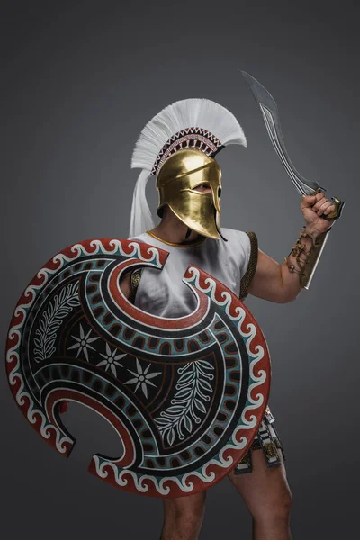 丸みを帯びたシールドとグラディウスを保持黄金のヘルメットとアンティークギリシャの兵士のショット — ストック写真