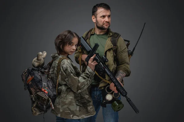 Студийный Снимок Постапокалиптического Военного Мужчины Защищающего Молодую Девушку Серого Фона — стоковое фото