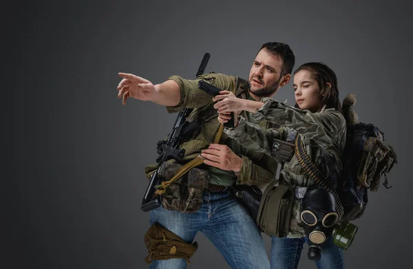 男の肖像画訓練少女に銃を撃つためにポスト黙示録の設定で — ストック写真