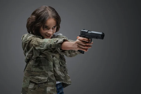拍摄疯狂的年轻女孩与灰色背景手枪迷彩服 — 图库照片