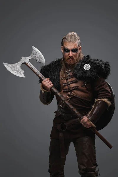 革製の鎧と毛皮を身に着けている斧を保持する赤毛のスカンディナヴィアの野蛮人のショット — ストック写真