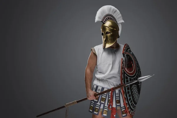盾と槍で古代ギリシャからグレーの背景兵士に隔離されたスタジオショット — ストック写真
