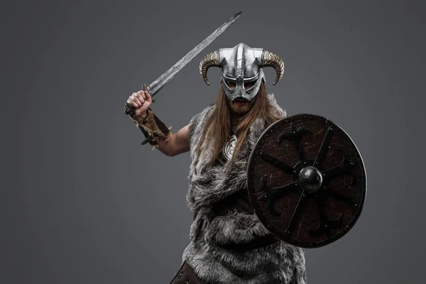 灰色の背景を持つ盾と剣を持つアンティーク北部の戦士のスタジオショット — ストック写真