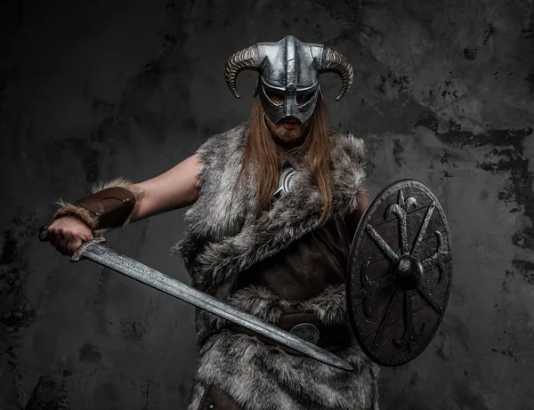 戦いの姿勢でポーズをとる毛皮の服を着た野蛮バイキングの肖像 — ストック写真