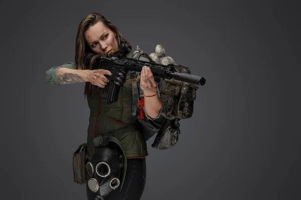バックパックとライフルで女性傭兵を攻撃するスタジオショット — ストック写真