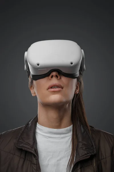 隔离在灰色背景的女人身上 戴着创新的虚拟现实的护目镜 — 图库照片