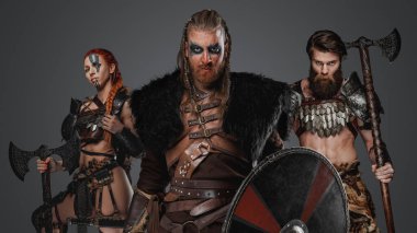 Studio shot of antique three viking with axes looking at camera. clipart