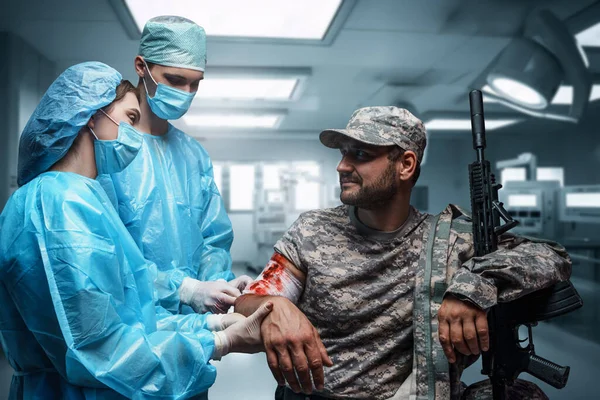 Постріл Пораненого Військовослужбовця Гвинтівкою Лікують Два Хірурги — стокове фото