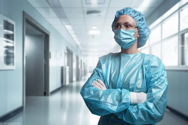 現代病院の廊下に対して交差腕でポーズ外科医の女性のショット — ストック写真