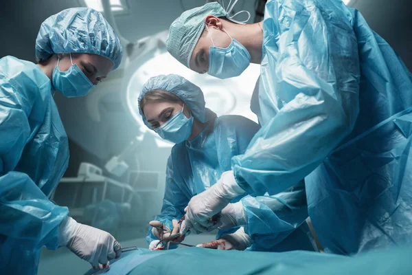 Colpo Tre Chirurghi Vestiti Con Accappatoi Maschere Con Paziente Sala — Foto Stock
