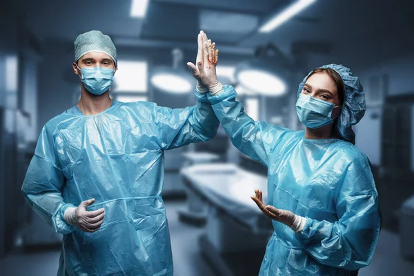 Постріл Двох Лікарів Масками Халатами Дивиться Камеру Операційній Кімнаті — стокове фото