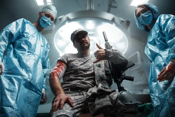 Πυροβολισμός Στρατιωτικού Που Κοιτάζει Κάμερα Δύο Χειρουργούς Στα Πλευρά Του — Φωτογραφία Αρχείου