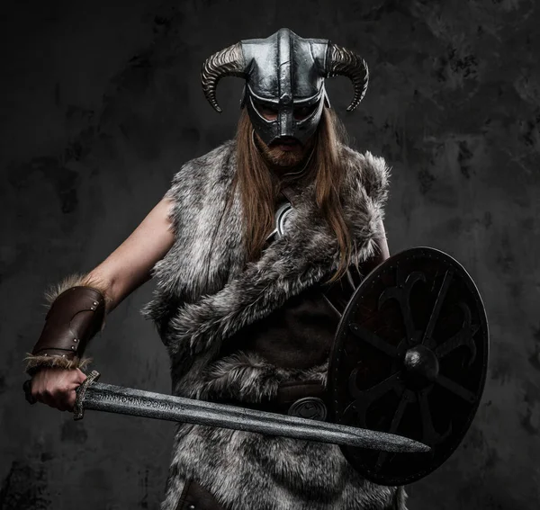 戦いの姿勢でポーズをとる毛皮の服を着た野蛮バイキングの肖像 — ストック写真