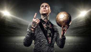 Dövmeli vücutlu modaya uygun futbolcu sanatı büyük stadyum ve ışıklı ışıklara karşı.