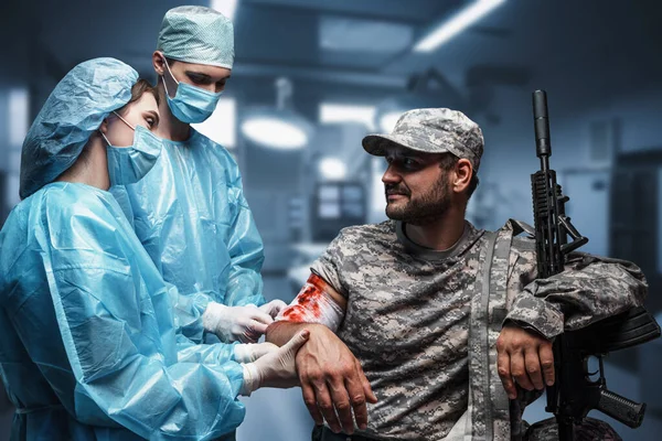 Постріл Пораненого Військовослужбовця Гвинтівкою Лікують Два Хірурги — стокове фото