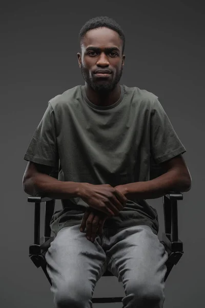 Studio Shot Serious Black Guy Assis Sur Chaise Regardant Caméra — Photo