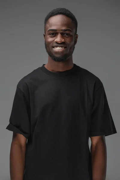 スタジオショットの笑顔黒男でスタイリッシュな髪型でTシャツ — ストック写真