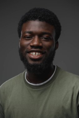 Gri arka planda izole edilmiş bir stüdyo resmi. Günlük giyinmiş siyahi bir adam..