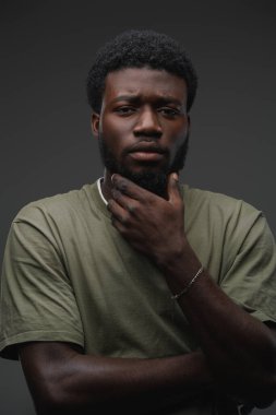 Afrikalı etnik bir adamın portresi. Kameraya bakarak çapraz kollarla poz veriyor..