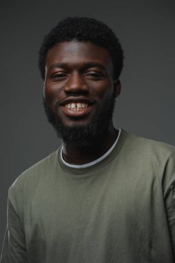 Gri arka planda izole edilmiş bir stüdyo resmi. Günlük giyinmiş siyahi bir adam..